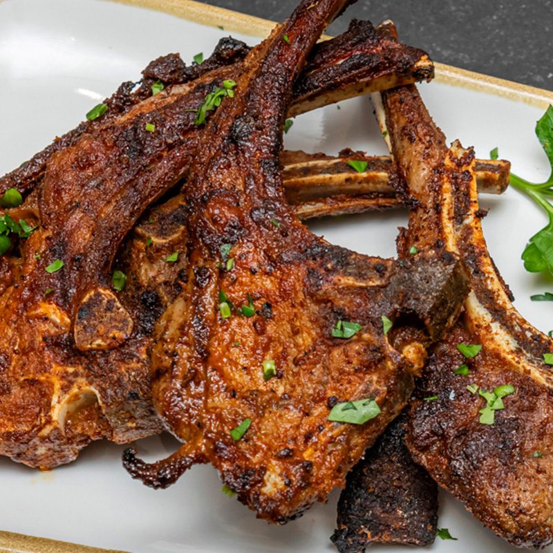 4 baby braai lamb chops; flame-grilled to perfection with our signature Truro spice blend from The Truro in South Croydon